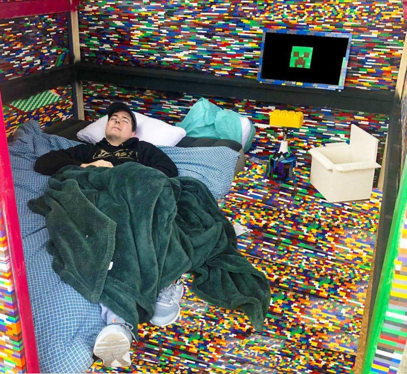 mr beast sleeping on a bed with minecraft all around him
