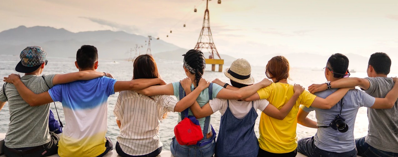 people sitting and hugging looking at the ocean