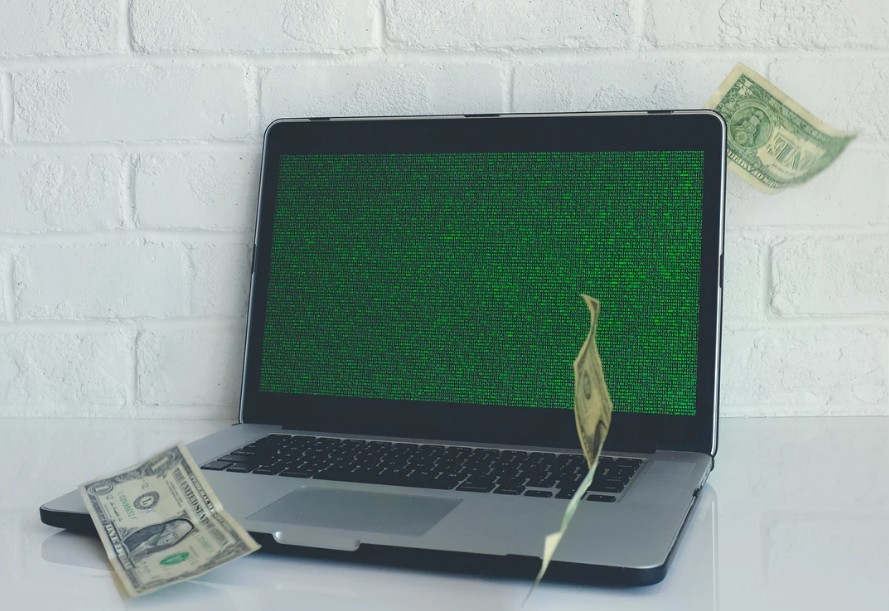 laptop with a dollar bill next to it